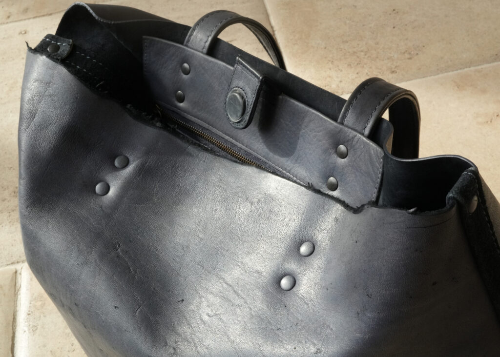 切りっぱなしのエッジと革巻き金具のこだわり